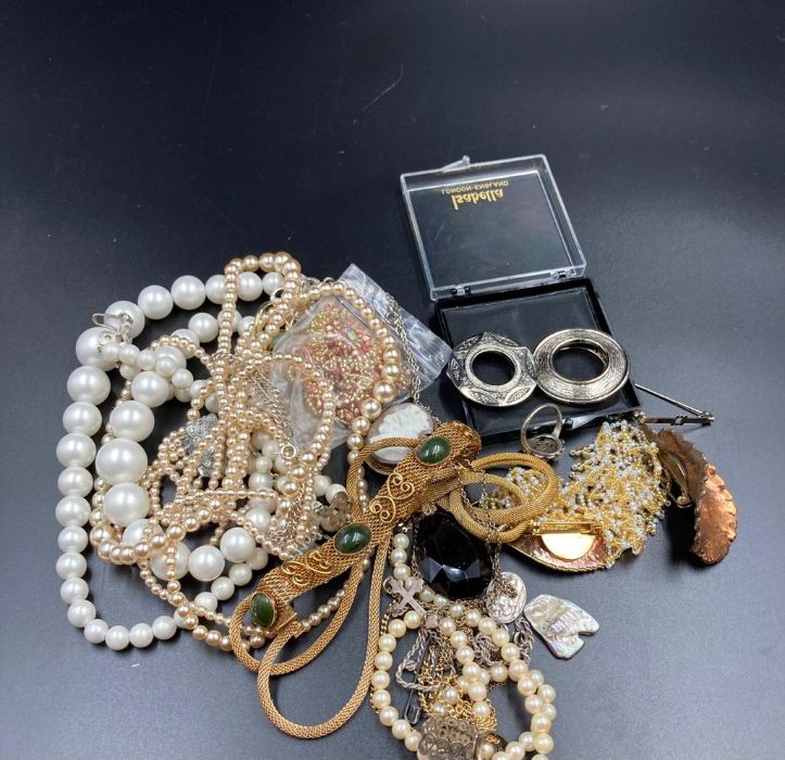 A small volume of costume jewellery to include brooches, pearl necklaces etc.