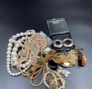 A small volume of costume jewellery to include brooches, pearl necklaces etc.