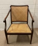 A mahogany cane seated arm chair