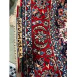 A red, blue and beige with star motif rug, signed Seirafian (161cm x 254cm)