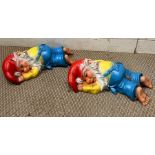 Two garden gnomes laying down