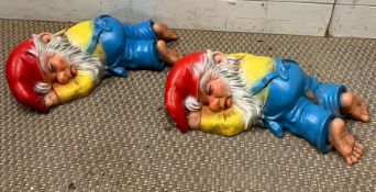 Two garden gnomes laying down