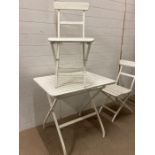 A metal and wooden white painted folding bistro set
