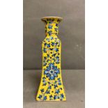 A porcelain Chinese blue, white and yellow candle stick with a floral decoration