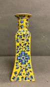 A porcelain Chinese blue, white and yellow candle stick with a floral decoration
