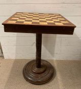 An antique mahogany chess table on a round hand carved base