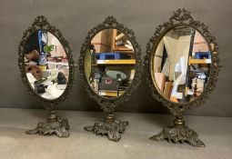 Three vintage bronze weathered table mirrors with ornate floral details