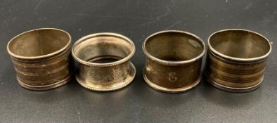 Four silver napkin rings, various hallmarks and makers.