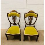 A pair of low bedroom chairs with green upholstery