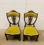 A pair of low bedroom chairs with green upholstery