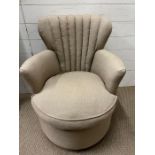 An upholstered tub arm chair, fluted back and circular seat