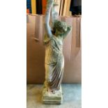 A garden statue of a lady carrying a vase