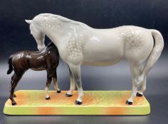 A hand painted Beswick figurine of a grey mare doting on a black foal