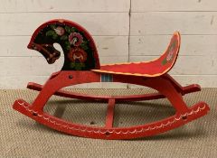 A Russian hand painted wooden rocking horse with floral decoration