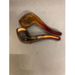 An antique pipe with amber stem and silver mount.