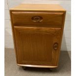 An Ercol single drawer cupboards on castors (H70cm W46cm D44cm)