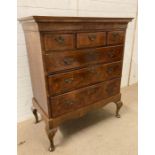 An 18th Century walnut veneered chest on stand with three short and three long drawers and brass