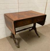 A flame mahogany two drawer drop leaf sofa table on lion paw feet finishing on castors (H77cm