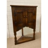 A gothic oak shelved corner cabinet Height 98cm Width 65cm Depth 36cm