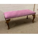 A purple upholstered foot stool