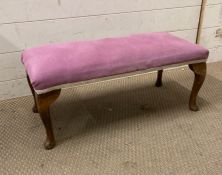 A purple upholstered foot stool