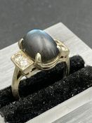 A vintage ring with two diamond shoulders and central blue stone on platinum band. Size G