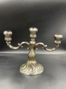 A three arm continental silver, marked 800, candlestick. Filled and 21.5cm H