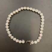 A diamond bracelet set in 18ct white gold. The links are made of little clusters of a center diamond