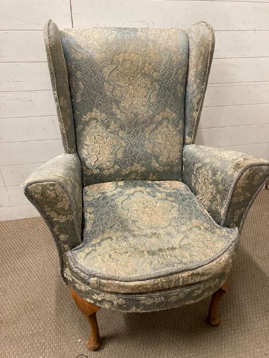 A wing back armchair upholstered in a blue and white floral pattern