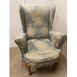 A wing back armchair upholstered in a blue and white floral pattern