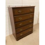 A five drawer chest with brass relief on castors (H140cm W84cm D45cm)