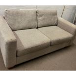 A beige two seater sofa (H100cm W185cm D100cm)