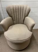 An upholstered tub arm chair, fluted back and circular seat
