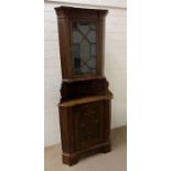 An oak corner unit with lead glazed top and panelled cupboard doors (H206cm W90cm D61cm)