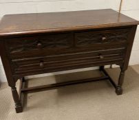 An oak low sideboard with three drawers (H76cm W106cm D48cm)