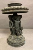 A cast iron tiered fountain with cherubs to centre
