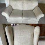 A two seater sofa and arm chair upholstered in white