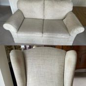 A two seater sofa and arm chair upholstered in white