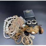 A small volume of costume jewellery to include brooches, pearl necklaces etc.