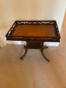 A mahogany galleried side table with brown leather top and brass lion paw feet