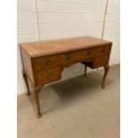 A burr walnut desk with a leather top on cabriole legs (H 77cm x D 49cm x W114cm)