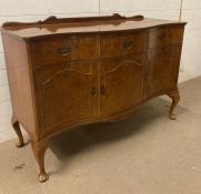 A three drawer, three cupboard sideboard on cabriole legs with serpentine front, brass handles and