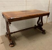 A Victorian library table with rectangular top each end with harp supports united by a turned
