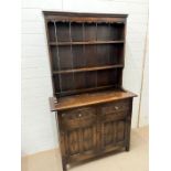 An oak dresser with carved panelled doors below (H180cm W108cm D40cm)