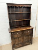 An oak dresser with carved panelled doors below (H180cm W108cm D40cm)