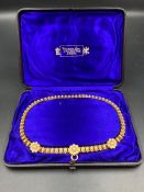 A Victorian Pinchbeck and pearl necklace in purple silk lined box from Watherston & Son 12 Pall Mall