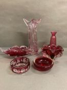 A selection of cranberry glassware to include an ash tray, bowls and a vase