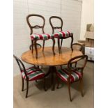 A circular dining table and six mahogany balloon back dining chairs, four matching