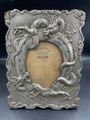 A Japanese antique dragon twisting around a horseshoe themed picture frame in white metal (24.5cm