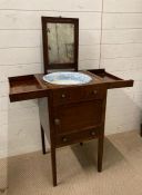 A mahogany wash stand with white and blue ceramic wash bowl and mirror to back